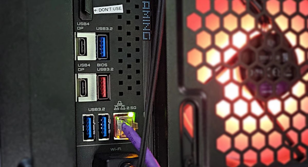 PC back panel showing display cable plugged into GPU instead of motherboard, highlighting correct monitor connection setup for better graphics performance.
