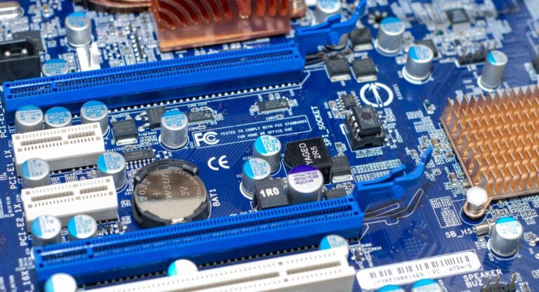 CMOS battery on motherboard close-up showing coin-shaped CR2032 lithium battery used for BIOS settings, system time, and hardware configuration storage.